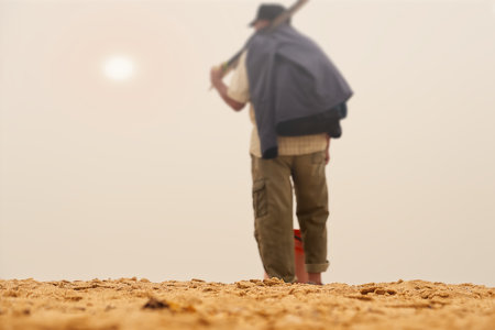 Agricultural worker working on the field in the early morning.の写真素材