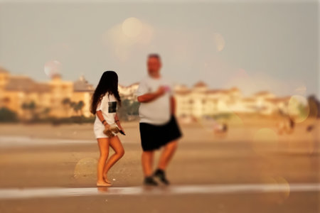 Couple walking on the beach with soap bubbles in the background.の写真素材