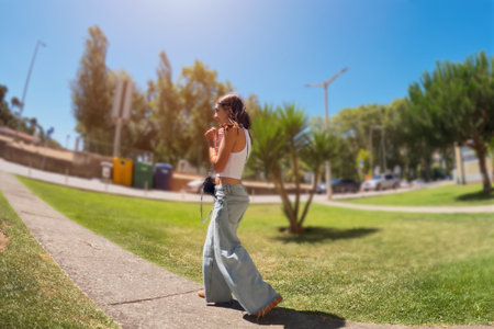 Young woman in long jeans walking in the park.の写真素材