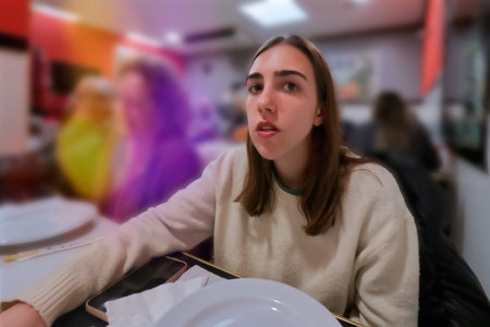 Portrait of a beautiful young woman sitting in a cafe and eatingの写真素材