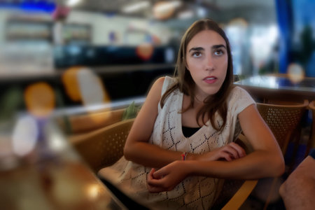 Young woman sitting in a coffee shop and looking at the camera.の写真素材