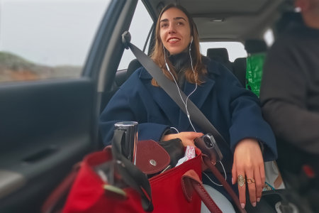 Young woman in a car on a road trip with her family.