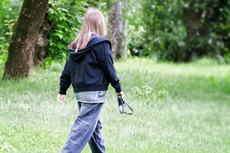 Young woman walking in the park. Back view. Copy space.の写真素材