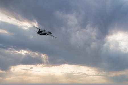 Aerial view of a military drone flying in a cloudy sky.の写真素材
