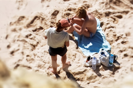 Two women sitting on the sand.の写真素材