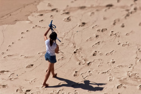 Little girl waking up on the beach in the sand with a toy airplaneの写真素材