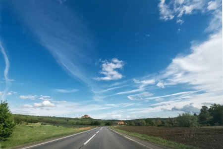 Asphalt road with blue sky and white clouds in the background.の写真素材