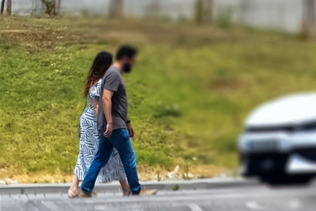 Young couple walking on the road in the city. Blurred background