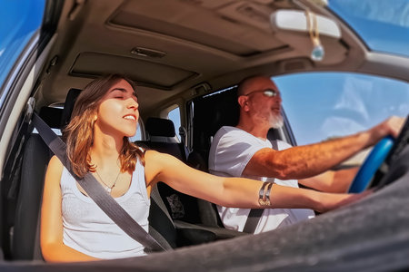Young couple driving a car on a sunny day.の写真素材