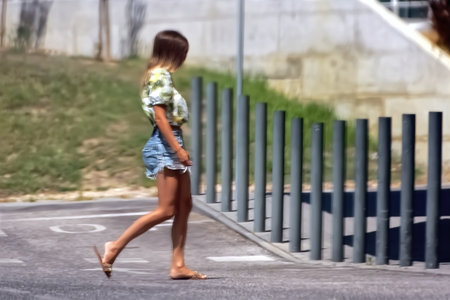 Woman walking on the street. Blurred background. Sunny day.の写真素材