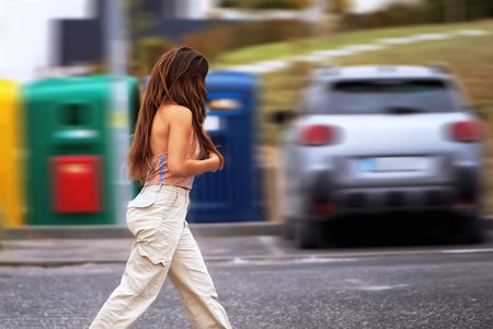 Young woman crossing the road in the city. Blurred motion.の写真素材