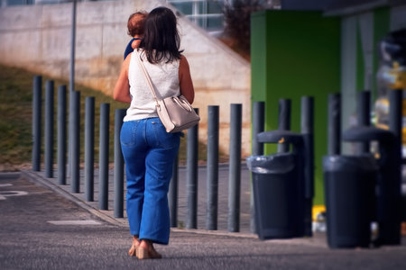 Back view of young woman walking on the street with her handbagの写真素材