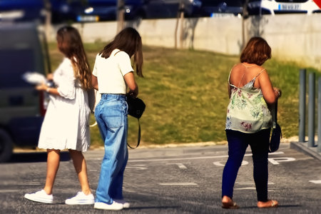 Three women walking in the city. Back view. Blurred background.