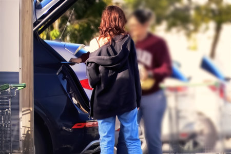 Young woman opening the door of a car in the parking lot.の写真素材
