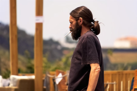 Portrait of a man smoking a cigarette in a restaurant on the terraceの写真素材