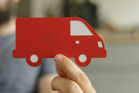 Delivery Service: Red Truck Icon Held by Hand