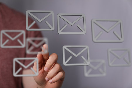 Person Interacting with Email Icons on a Screenの写真素材