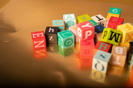 Close up of colorful toy cubes with letters on a brown background.の写真素材