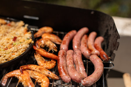 barbecue with sausages and prawns on the grillの写真素材