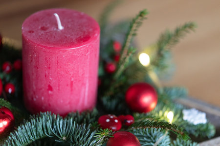 Christmas centerpiece with red candle, ornaments, and fir branches. Festive holiday decor.の写真素材