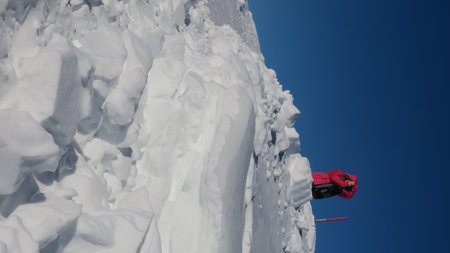 Person in Red Jacket on Snowy Mountain Peak