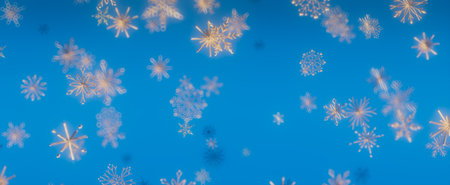 A serene image of snowflakes falling against a bright blue background.の写真素材