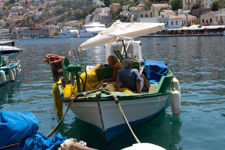 Greek Fisherman Mending Nets in Picturesque Harbor