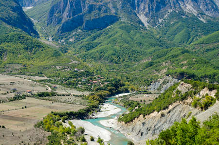 Aerial view of the valley with turquoise river flowing through the mountainsの写真素材