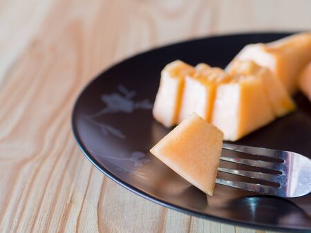 Fresh Cantaloupe melon slices on wooden table.の写真素材