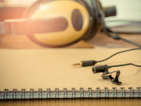 clip microphone on the book and Headphones on the table . sounds concept. vintage filter effect.の写真素材