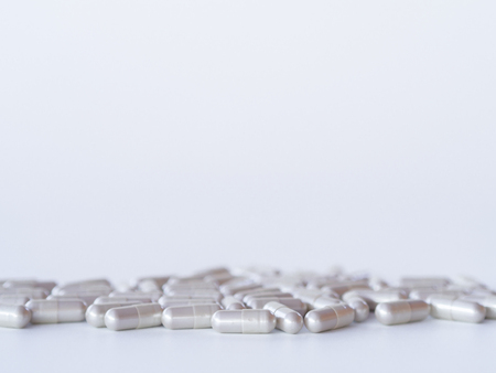 Pills spilling out of the bottle on white background.の写真素材