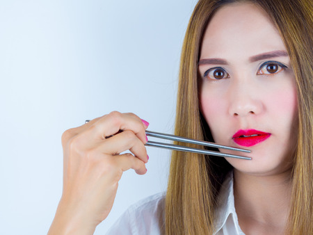 Asian Women use chopsticks, on white background.の写真素材