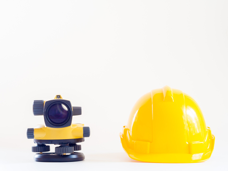 theodolite and construction helmet on white background.