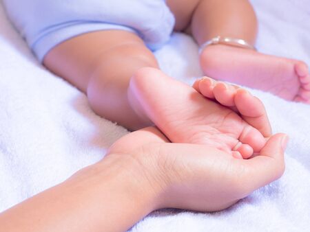 Baby feet in mother hands. Mother's love for Baby concept.の写真素材