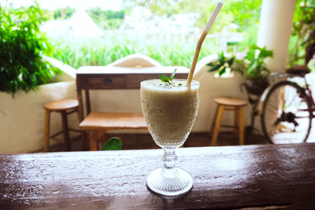 Coconut milk smoothie in a glass with a straw.