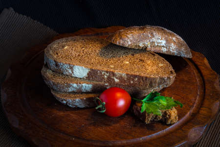 Fresh bread on wooden table,vintage filter, Traditional black rye-bread on dark background,  Red...
