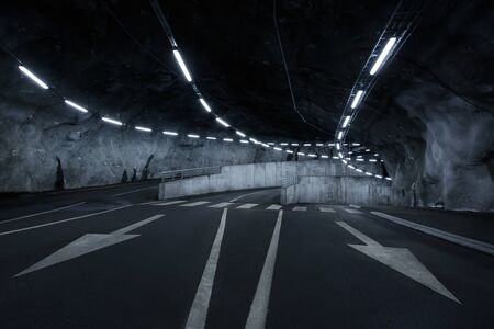 Sci-fi looking dark and moody underground parking lot with fluorescent lights on.