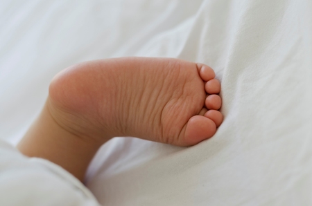Cute tiny little white baby feetの写真素材
