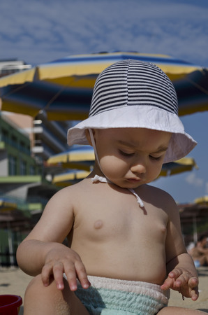 Beautiful baby playing on the sand in Bulgarian resortの写真素材
