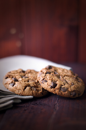 Cookies with chocolate crumbs on linen napkin on dark brown backgroundの写真素材