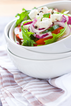 Greek salad in white ceramic bowl on textil napkinの写真素材