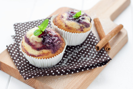 Blueberry muffins on wooden board with cinammon sticksの写真素材