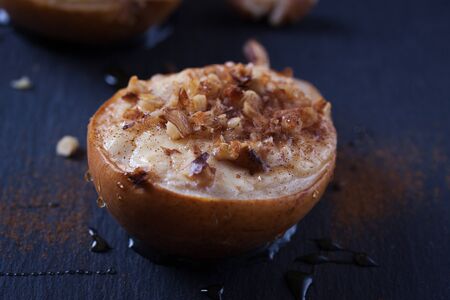 Baked pears with cottage cheese, honey and walnuts on dark background