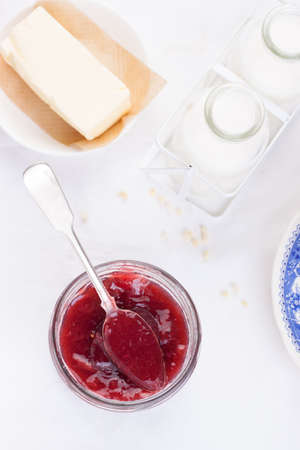 Jam with red grape in a glass jar on a white background. Top viewの写真素材