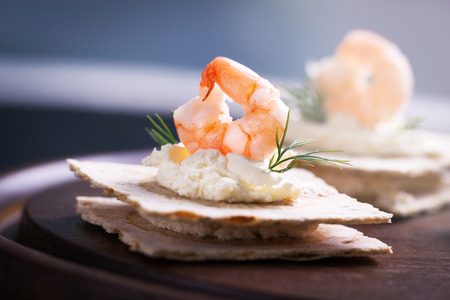 Appetizer canape with shrimp, cheese and dill on a small loaf of bread, closeupの写真素材