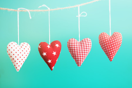 Beautiful red plush hearts hanging on rope with beautiful light on a colorful background, horizontal, valentine's day or love conceptの写真素材