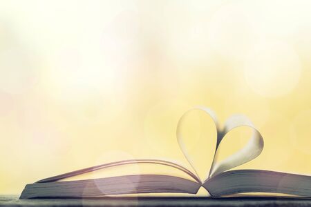 Love, valentine's day or reading concept with heart shaped book on bokeh background, copy space, horizontalの写真素材