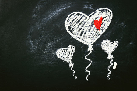 Creative Love or Valentine's Day Concept with Balloons in Heart Shape Form, Drawing on a Chalkboard. Horizontal with Copy Spaceの写真素材