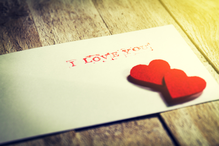 Envelope with message I love you and hearts on a wooden background. Love conceptの写真素材