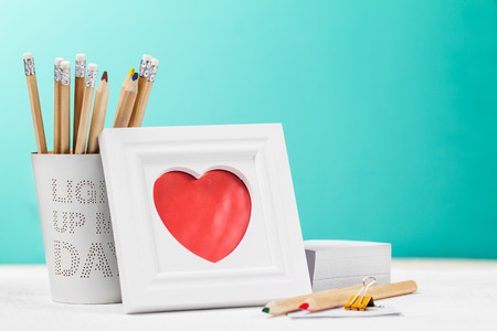 Love concept with photo frame, pencils and red heart. Horizontal with copy space.の写真素材